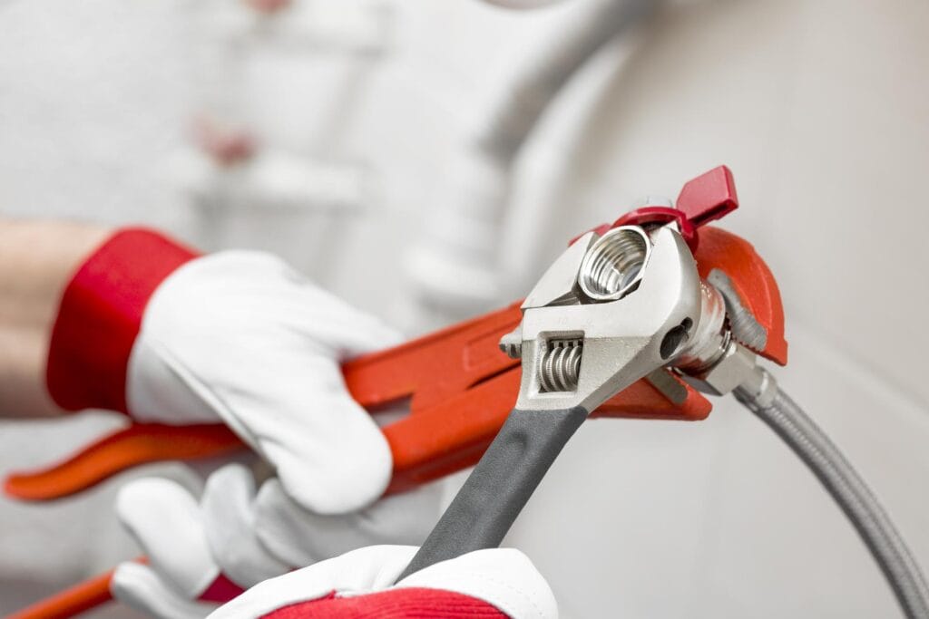 Plumber tightening pipe fitting for residential plumbing repair in Homestead, Florida